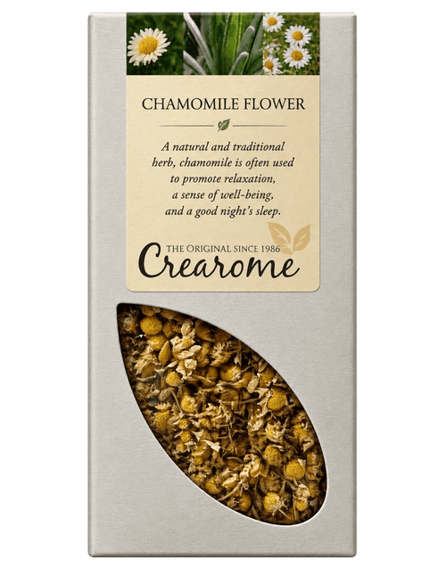 A rectangular cream-colored box of Crearome Chamomile Flower tea, featuring a clear window on the lower half that displays the loose chamomile flowers and leaves inside.